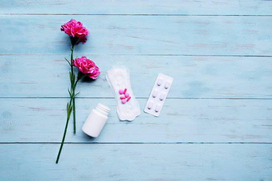 Sanitary Pad With Pills And Roses On Table