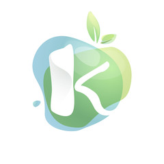 K letter logo with negative space at green watercolor splash background.