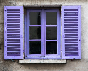 lilac painted window shutter on grungy concrete wall background