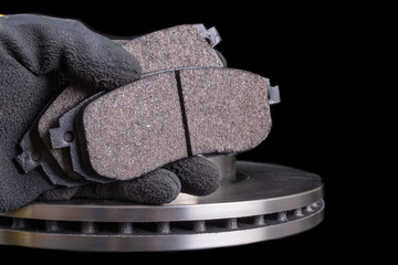 Brake pad for a passenger car in the hand of a mechanic. New spare parts for car repairs. © Piotr