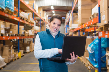 female warehouse worker using a laptop