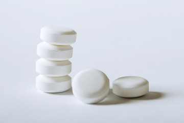 White pharmacy pills on a white background.