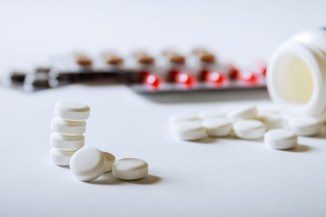 White pharmacy pills on a white background.
