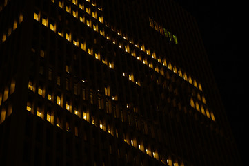 Night skyscraper closeup, glowing window. Night work