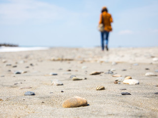 stones on a beach with blur woman silhouette