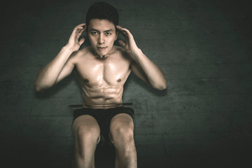 Young man doing crunches exercises on the floor