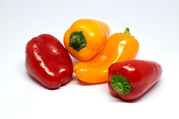 Je zwei kleine gelbe und rote Paprika, isoliert auf weißem Hintergrund
