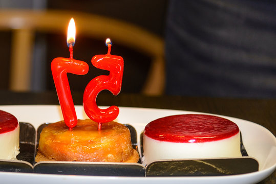 Pastel de aniversario con dos velas , con el numero 57