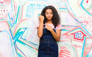 young pretty african american woman looking impatient and angry, pointing at watch, asking for...