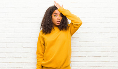young black woman raising palm to forehead thinking oops, after making a stupid mistake or...