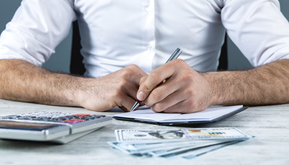 businessman considers company income sitting in office