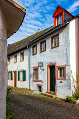 Colorful cobblestone street view of Kronenburg, North Rhine-Westphalia, Germany, adjoining buildings against November cloudy sky