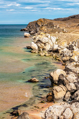 Crimea, Russia. Scenic landscape of Azov Sea coast known as Generals' Beaches. Sandy seashore and rocky cliffs under blue sky scenery