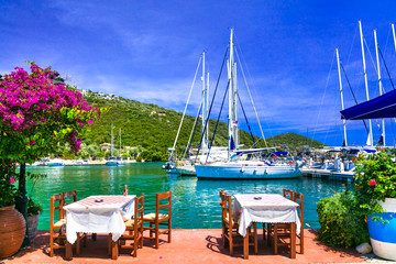 Traditional Greek restaurants (taverns) near the sea. Sivota fishing village in Lefkada island - obrazy, fototapety, plakaty