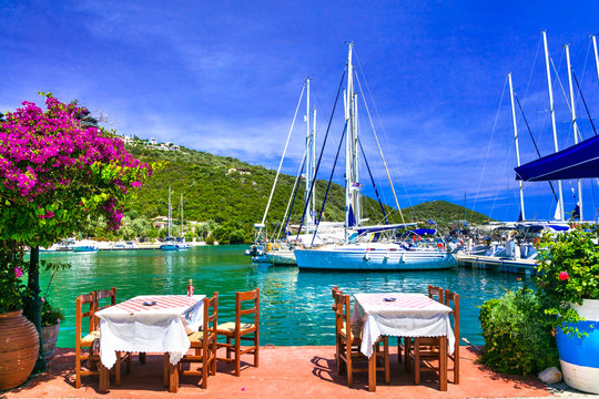 Traditional Greek Tavern Tables by the Sea: Waterfront Dining in Sivota Fishing Village, Lefkada Island, Ionian Sea View with Sailing Yachts and Boats, Mediterranean Aesthetics, Summer Vacation 6K