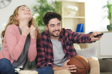 couple basketball supporter watching the television