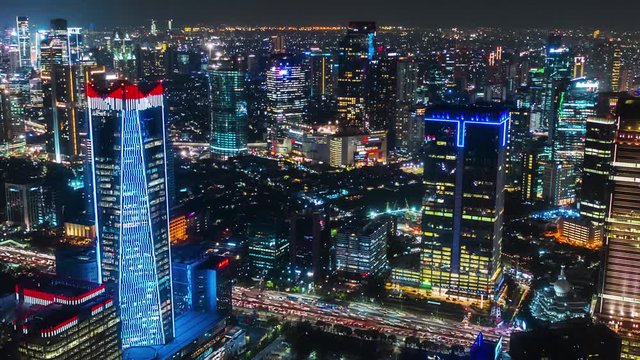 JAKARTA, Indonesia - October 07, 2019: Beautiful aerial hyperlapse of business district with skyscrapers and night lights. Shot in 4k resolution from a drone flying forwards
