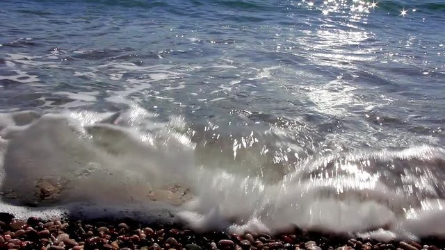 Closeup pebble stones on a beach with soft focus by the sea, waves and skylin, coastlinae of Montenegro