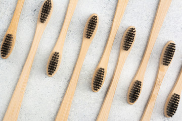 Zero waste eco friendly bamboo toothbrushes on white table, top view, selective focus