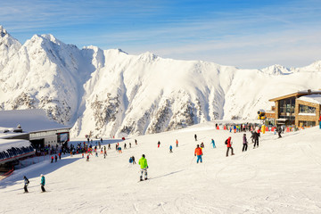 Many skiers and snowboarders riding over Idalp downhill plato at austrian alipine Ischgl resort on...