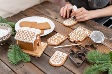 Christmas homemade gingerbread cookies on wooden table. Icing of Christmas bakery. closeup, copy space. Blank biscuit gingerbread house, ready to decorate.