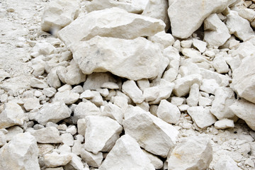 A pile of white stones, cobblestones. Large and small calcareous stones of white color.