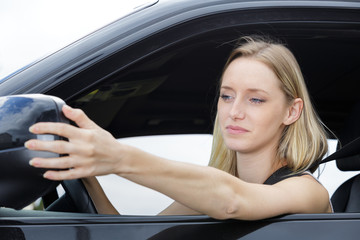 young woman fixing car side mirror