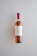 top view of bottle with rose wine and blank label on white background