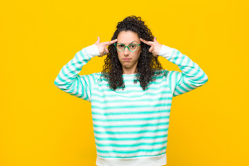 young pretty woman with a serious and concentrated look, brainstorming and thinking about a...