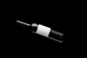 top view of bottle with wine and blank white label isolated on black