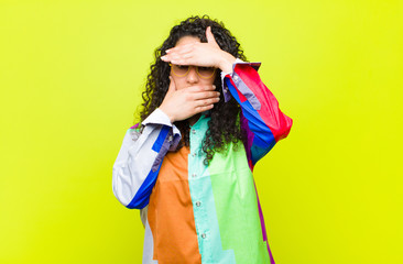 young pretty woman covering face with both hands saying no to the camera! refusing pictures or...