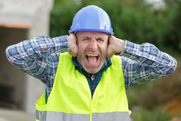 engineer covering ears and closing eyes