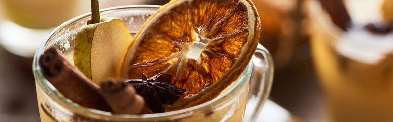 close up view of delicious pear mulled wine with spices and dried citrus, panoramic shot