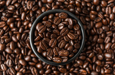 Fototapeta premium Roasted coffee beans in a black bowl