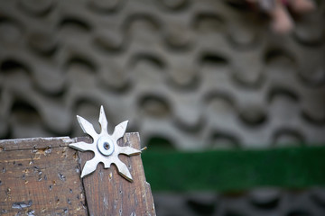 Close-up throwing board for throwing star decorated with broken shurikens, selective focus