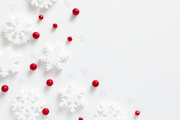 Christmas holiday composition. White snowflakes, Xmas red decorations on white background. Christmas, New Year, winter concept. Flat lay, top view, copy space