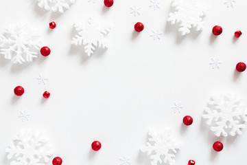 Christmas holiday composition. White snowflakes, Xmas red decorations on white background....