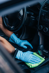 cropped view of car cleaner wiping gear whifter with rag