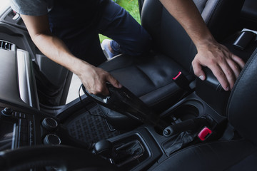 cropped view of car cleaner vacuuming car interior