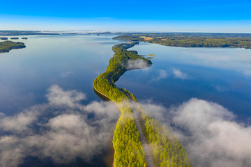 Luftaufnahme von Pulkkilanharju Ridge, Paijanne National Park, südlicher Teil des Lake Paijanne. Landschaft mit Drohne. Nebel, blaue Seen, Felder und grüne Wälder von oben an einem sonnigen Sommermorgen.