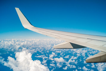 Fototapeta na wymiar Plane Wing During Flight Over United States With Blue Sky and Small White Clouds
