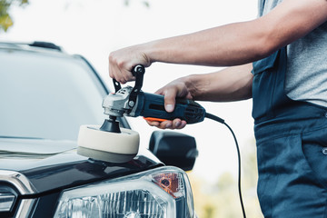 cropped view of car cleaner polishing car with buffer machine