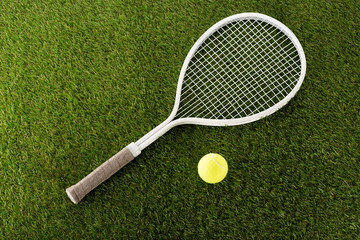 top view of tennis racket and ball on green grass, sports betting concept