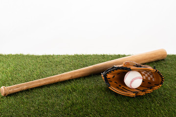 baseball bat, glove and ball on green grass isolated on white, sports betting concept