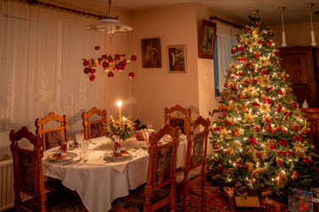 The christmas tree in the christmas eve with lot of presents. Beautiful diner  table.