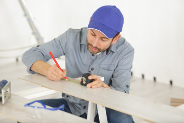 carpenter at work measures with the meter and pencil