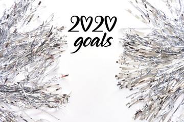 Silver metal foil tinsel strips isolated on white background, christmas, festive sparkling decor garland. 2020 New year goals flat lay, copy space. Planning concept. Wish desire checklist
