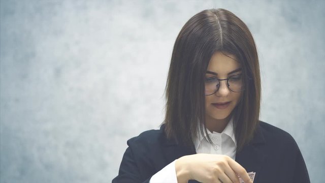 Confident young businesswoman, mafing a fan of money banknotes, smiling happily, dreaming.