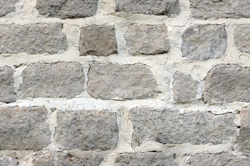 Seamless texture of large masonry from hand-carved blocks of a fortified wall with lime mortar.