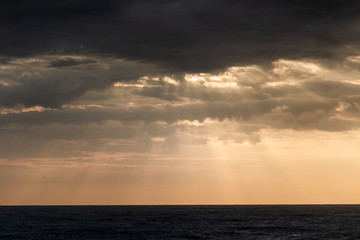 Sunrays through storm clouds during sunrise 